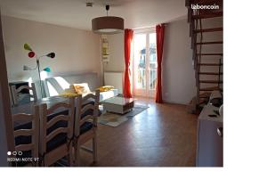 a living room with a dining table and a living room with a couch at L'Amandier in Néris-les-Bains