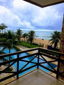 a balcony with a view of a beach and palm trees at Beach Front Apartment Kariri in Caucaia