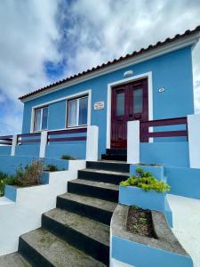 a blue house with stairs and a red door at Casa da Avó Elvina in Angra do Heroísmo