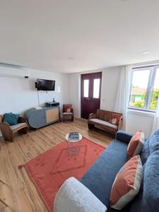 a living room with a blue couch and a tv at Casa da Avó Elvina in Angra do Heroísmo