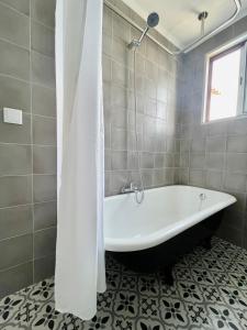 a white bath tub in a bathroom with a window at Casa da Avó Elvina in Angra do Heroísmo +14 photos