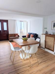 a living room with a table and chairs and a couch at Casa da Avó Elvina in Angra do Heroísmo