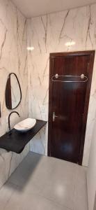 a bathroom with a sink and a wooden door at Vieira's Residencial in Embu +11 photos