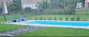 a swimming pool with two blue chairs in a yard at Casa Paradiso Salta in Salta