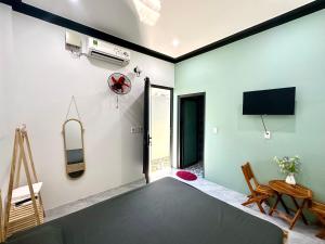 a living room with green walls and a flat screen tv at Hera motel in Xã Như Lâm