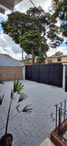 a large courtyard with a fence and a tree at Vieira's Residencial in Embu