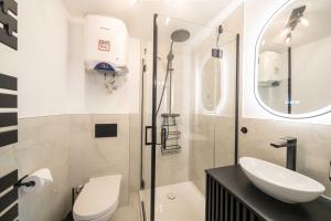 a bathroom with a shower and a toilet and a sink at NORDÉA Apartments in Rostock +63 photos