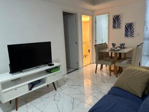 a living room with a flat screen tv on a entertainment center at Refúgio Azul Vog Ville Sul in Caruaru