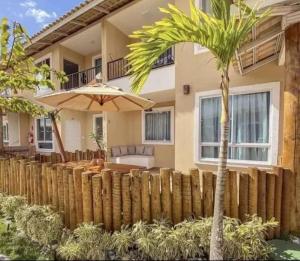 a palm tree in front of a house with a fence at Refúgio Azul Vog Ville Sul in Caruaru