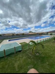 a large swimming pool with a palm tree next to it at Refúgio Azul Vog Ville Sul in Caruaru