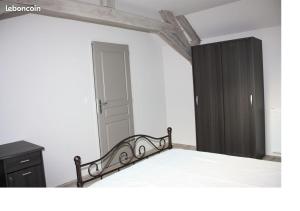 a bedroom with a bed and a black cabinet at L'Amandier in Néris-les-Bains +3 photos