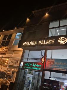 a building with a sign for a malza palace at Malaga palace in Soûr
