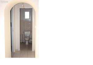 a bathroom with a white toilet in a hallway at L'Amandier in Néris-les-Bains