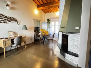 a living room with a fireplace and a table and chairs at La Casa di Thor in Porto Azzurro