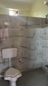 a white bathroom with a toilet and a window at Apartment in Khardaha in Khardah