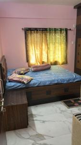 a bedroom with a bed with a yellow curtain at Apartment in Khardaha in Khardah +8 photos