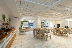 a large kitchen with wooden tables and chairs at Sercotel Kalma Sitges in Sitges