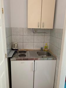 a small kitchen with a sink and white cabinets at Studio Apartments Ivo in Baška Voda