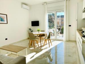 a white living room with a table and chairs at Corso 42 in Novara