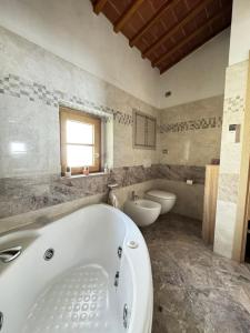 a large bathroom with a tub and two toilets at La Casa di Thor in Porto Azzurro