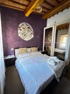 a bedroom with a large bed with a purple wall at La Casa di Thor in Porto Azzurro