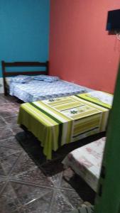 a bedroom with two beds with a table in it at Pousada Nosso cantinho in Belém