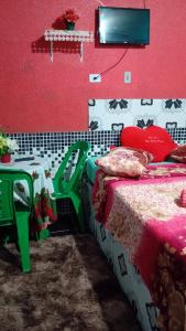 a bedroom with a bed and a red wall at Pousada Nosso cantinho in Belém