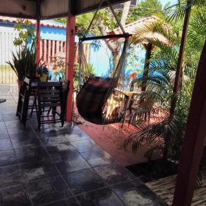 a porch with a hammock and a table and chairs at Pousada Nosso cantinho in Belém