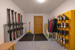 a room with a bunch of skis on the wall at Luxury Family Ski Chalet - Jacuzzi BBQ - Near Lake Golf - Multipass access 60 Summer activities - Sleep 10 in Les Gets
