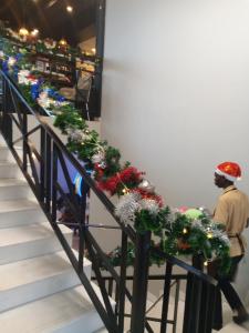 a stairway with christmas decorations and a man walking down it at Icon Hotel in Kampala