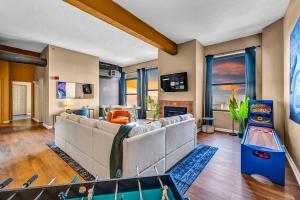 a living room with a couch and a video game at Fun 2Bed Apt Skeeball Foosball FREE Parking in Cleveland