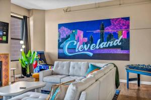 a living room with a couch and a painting on the wall at Fun 2Bed Apt Skeeball Foosball FREE Parking in Cleveland +18 photos