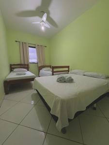 a bedroom with two beds and a ceiling fan at Pousada Costa Rio - Conforto e Hospitalidade em Rio das ostras in Rio das Ostras