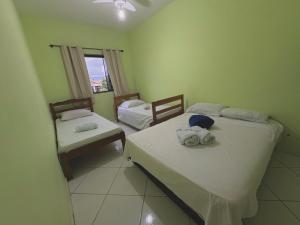 a room with two beds and a window at Pousada Costa Rio - Conforto e Hospitalidade em Rio das ostras in Rio das Ostras