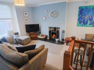 a living room with a couch and a fireplace at Riverdance Cottage in Lyme Regis