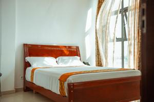 a bed in a room with a large window at Guest House Lumen in Lomé