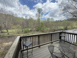 a balcony with two chairs and a table and a river at Rivers Edge 803c in Helen +5 photos