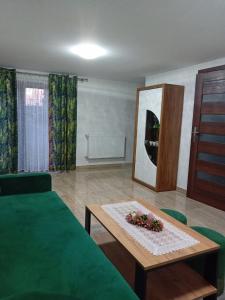 a bedroom with a bed and a table and a mirror at Apartament pod Lipa blisko Term Chochołowskich in Ratułów