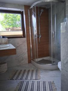 a bathroom with a shower with a glass door at Apartament pod Lipa blisko Term Chochołowskich in Ratułów +34 photos