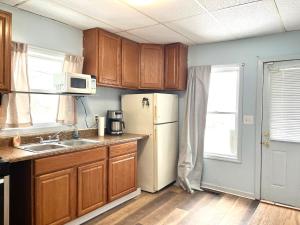a kitchen with wooden cabinets and a white refrigerator at Private Room-Shared Common Spaces-Queen Bed in Johnson City +6 photos