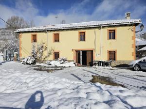 a house with snow in front of it at El txoko de onso in Santibáñez de la Peña