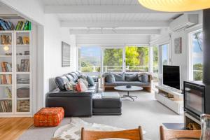 a living room with a couch and a tv at The Deck House in Lorne