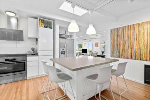 a kitchen with a table and chairs in it at The Deck House in Lorne