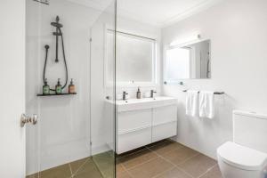 a white bathroom with a sink and a shower at The Deck House in Lorne +20 photos