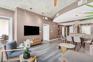 a living room with a couch and a tv on a wall at Spacious Apartment Masterfully Decorated in Orlando