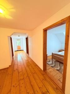 an empty room with a bed and a wooden floor at Cabana Eduard in Rişca +45 photos