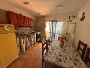 a kitchen with a table and a refrigerator at Complejo Samaya in San Clemente del Tuyú
