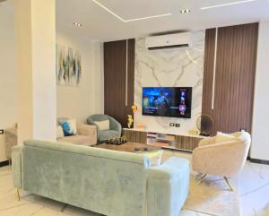 a living room with a couch and a tv at Luxury Royal Blue Family Villa 8pers private pool in Hurghada