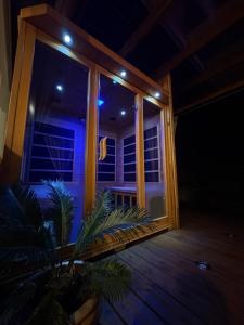 a room with a window at night with a plant at La Kaz 57 - Maison avec jacuzzi et sauna - La Réunion in La Plaine des Palmistes
