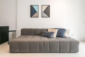 a couch in a living room with two pictures on the wall at WI-FI 200MB | Rooftop | Pool with Sea View #CA70D in Florianópolis
